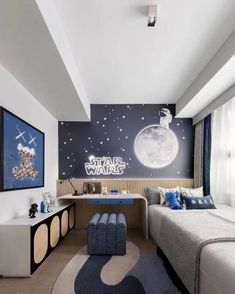 a bedroom with a bed, desk and wall mural in the background that says star wars