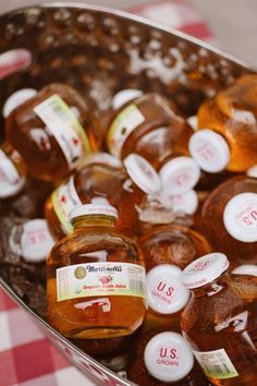 several bottles of syrup sitting on top of a red and white checkered table cloth