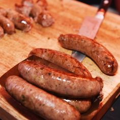 several sausages on a cutting board with a knife