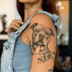 a woman with a dog tattoo on her arm and shoulder is looking at the camera