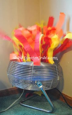 a metal basket filled with colorful streamers on top of a floor