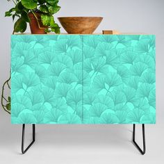 a plant is sitting on top of a cabinet with an interesting design in the front