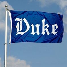 a blue flag with the word duke on it flying in the air next to a cloud filled sky