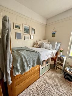 a bedroom with two twin beds and pictures on the wall above them, along with a rug