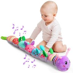 a baby sitting on the ground playing with a musical toy