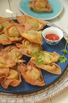 some food is on a blue plate with dipping sauce