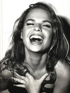 a black and white photo of a woman laughing