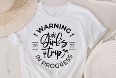 a white t - shirt with the words warning girls trip progress on it next to straw hats