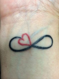 a heart tattoo on the wrist with an infinite love symbol in it's center