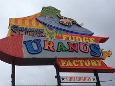 a large neon sign that says fudge uranos factory on it's side