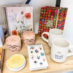 coffee cups, notebooks and other items are sitting on a table next to each other