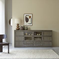 a living room with a large wooden cabinet in the corner and a chair next to it