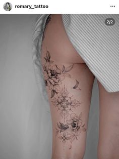 a woman's thigh with flowers on it and the bottom half of her leg