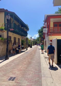 people are walking down the street in front of buildings