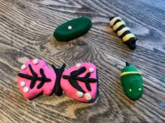 some very pretty decorated cookies on top of a wooden table with green and pink frosting