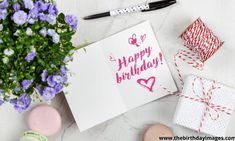 a birthday card sitting on top of a table next to some flowers and other items