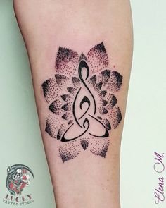 a black and white tattoo design on the left leg, with an abstract flower in the center