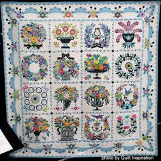 a quilt with flowers and vases on it