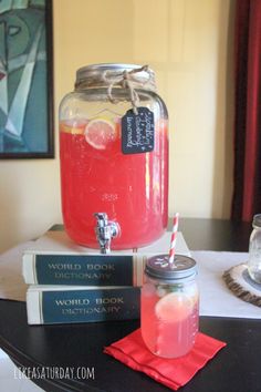 a glass jar filled with liquid sitting on top of a table next to some books