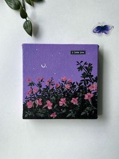 a purple book with pink flowers on it and a blue butterfly sitting next to it