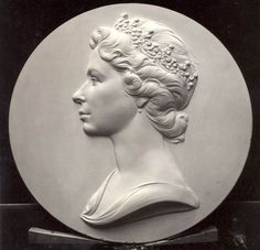 a white plaque with a woman's head on it