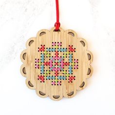 a wooden ornament with the word love spelled in beadwork on it