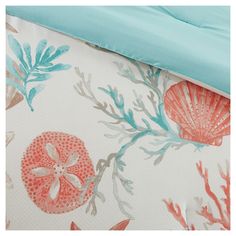 the bedding is made up with coral and seaweed print on it, along with a blue comforter