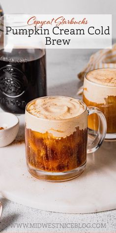 two mugs filled with pumpkin cream cold brew sitting on a table next to other drinks