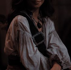 a woman wearing a white shirt and black belt around her waist, posing for the camera