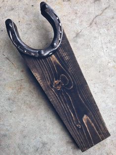 an old horseshoe hanging on the side of a wooden board