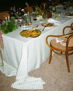 a table set up with food and flowers on it for a formal dinner or party