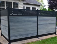 a fence that is made out of wood and black metal with grey paint on it