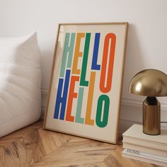 a framed poster sitting on top of a wooden floor next to a lamp and pillows