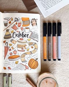 an open book sitting on top of a table next to some markers and pencils