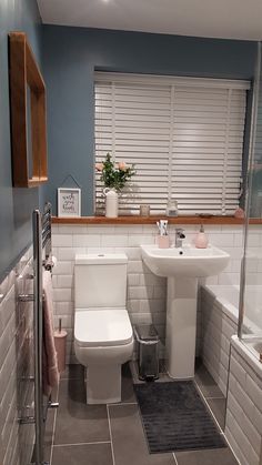 a white toilet sitting next to a sink in a bathroom