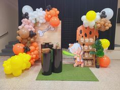 an assortment of balloons and decorations on display in front of a stage set up for a children's birthday party