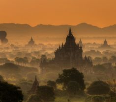 an aerial view of the temples in bagan, myanmar at sunset with hot air balloons