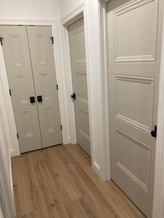 two white doors in a room with wood flooring and hard wood floors on both sides