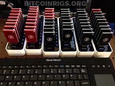 there are many black and red keyboards on the table next to each other, all lined up in rows