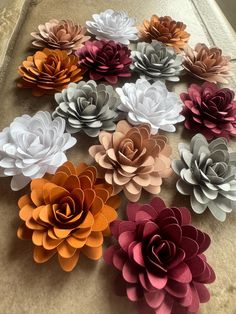 paper flowers are arranged on the table for decoration or wall hangings in various colors and sizes