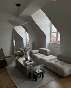 a living room filled with white furniture and lots of windows