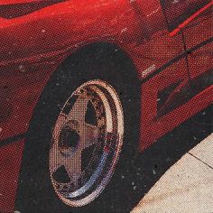 the front end of a red sports car with chrome wheels and rims on it