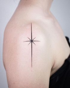 a woman's shoulder with a star tattoo on it