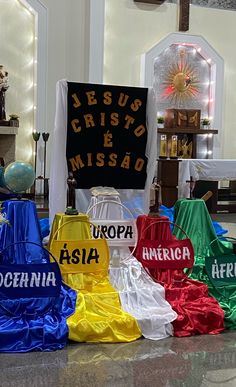 there are many different colored bags on the ground in front of a sign that says jesus christ & misssad