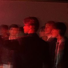 a group of young men standing next to each other in front of a red light