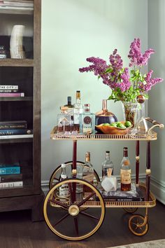 a bar cart filled with liquor bottles and flowers