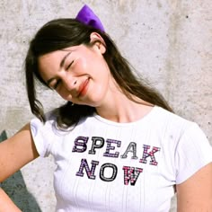 a woman with her hands on her hips wearing a t - shirt that says speak now