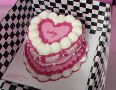 a heart shaped cake sitting on top of a checkered tray