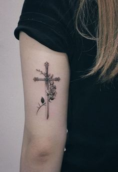 a cross with flowers on the arm and a knife in the other hand is shown