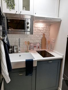 a kitchen with a sink, microwave and dishwasher on the wall above it